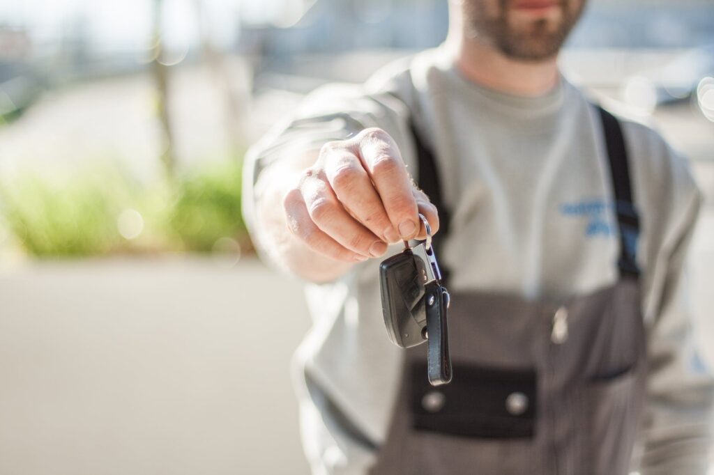 shallow focus car key held by a man