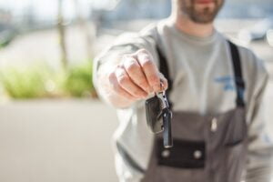 shallow focus car key held by a man